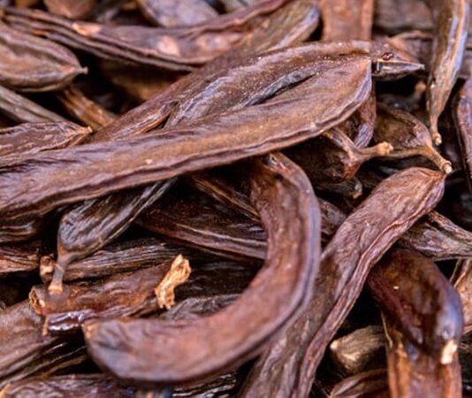 Akdeniz coğrafyasının en bilinen doğal ürünlerinden biri olan Keçiboynuzu, hem besleyici değeri hem de geleneksel kullanım alanlarıyla dikkat çeken bir meyvedir. Halk arasında “harnup” adıyla da bilinen bu besin, bilimsel olarak Ceratonia siliqua ağacının meyvesidir. Sıcak iklimleri seven bu ağaç, uzun ömürlü yapısı ve dayanıklılığı ile bilinir. Kahverengi, sert kabuklu ve tatlımsı aromaya sahip meyveleri hem taze hem de işlenmiş formlarda tüketilebilir. Konulu bir haber görseli.