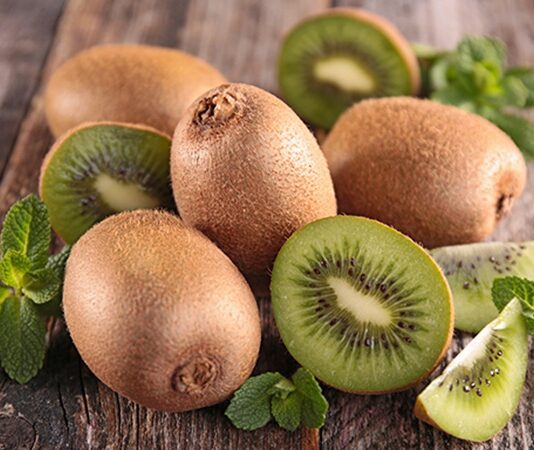 Son yıllarda sağlıklı beslenme listelerinde daha sık yer almaya başlayan kivi, hem lezzeti hem de zengin içeriğiyle dikkat çeken bir meyvedir. Dışı tüylü kahverengi kabukla kaplı olan, içi ise parlak yeşil ve siyah çekirdekli yapıya sahip olan kivi, ferahlatıcı aroması sayesinde özellikle kahvaltılarda ve ara öğünlerde tercih edilir. Tatlı ve hafif ekşi dengesiyle öne çıkan bu meyve, yalnızca damak zevkine değil sağlığa da katkı sunar. Konulu bir haber görseli.